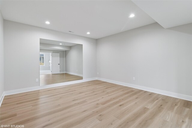 spare room with recessed lighting, light wood finished floors, and baseboards