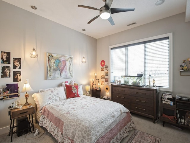 bedroom with light carpet, a ceiling fan, and visible vents