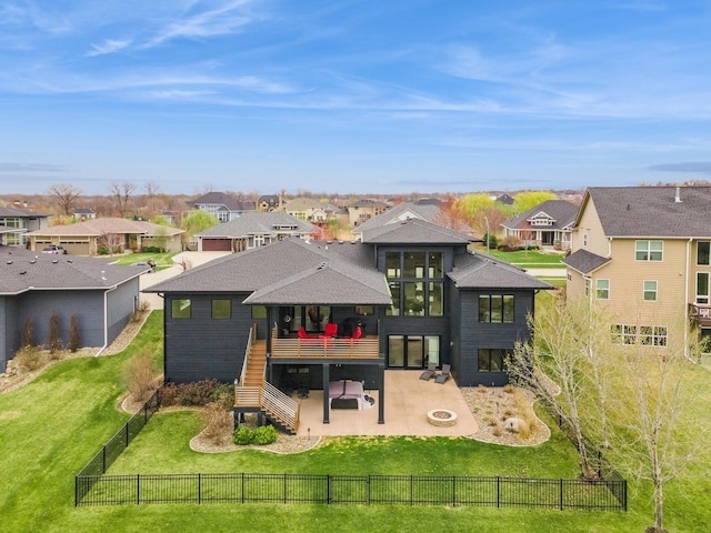 back of property featuring a yard, a fenced backyard, stairway, a patio, and a residential view