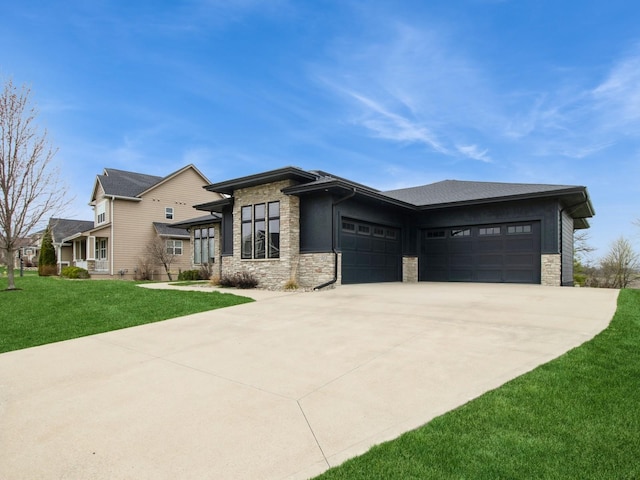 prairie-style house with a front yard, an attached garage, stone siding, and driveway