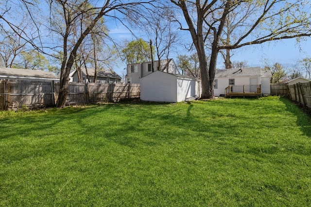 view of yard featuring a fenced backyard, a wooden deck, and an outdoor structure