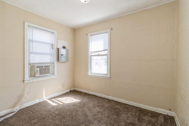 carpeted empty room featuring cooling unit, baseboards, and electric panel
