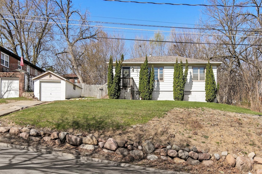 2010 S Union St, Des Moines, IA 50315 - ranch-style home featuring concrete driveway, an outdoor structure, a front yard, a garage, and fence