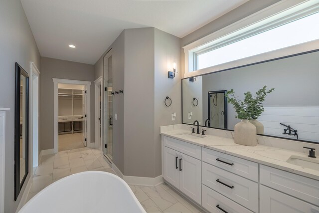 5009 148th Cir, Urbandale, IA 50323 - full bathroom featuring marble finish flooring, a stall shower, a spacious closet, a soaking tub, and double vanity