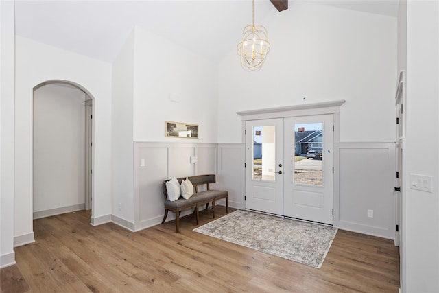 5027 NE Seneca Dr, Ankeny, IA 50021 - entryway with arched walkways, light wood-style flooring, a chandelier, high vaulted ceiling, and french doors