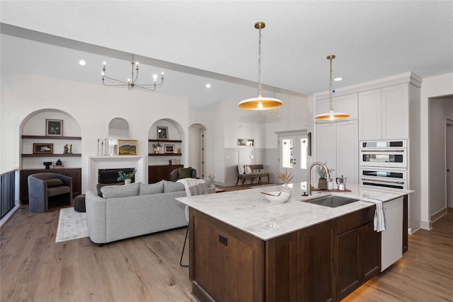 5027 NE Seneca Dr, Ankeny, IA 50021 - kitchen featuring a sink, built in shelves, light wood finished floors, recessed lighting, and lofted ceiling