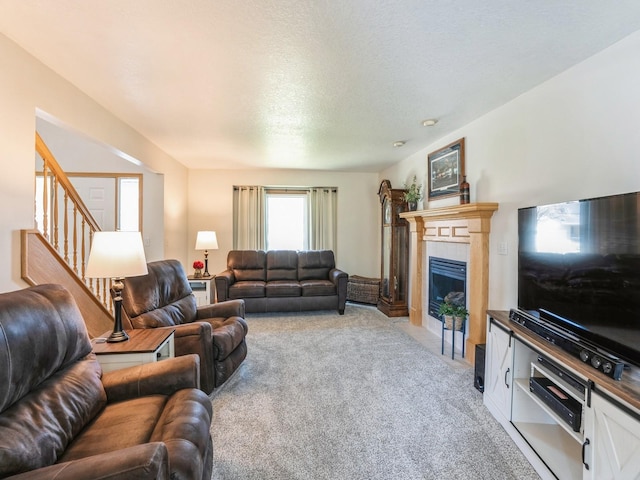 2917 SW Coves Dr, Ankeny, IA 50023 - living area featuring stairs, a tile fireplace, light colored carpet, and a textured ceiling