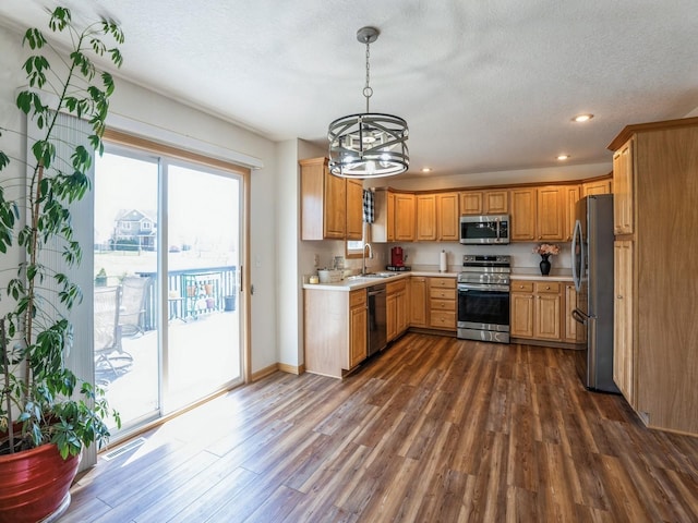 2917 SW Coves Dr, Ankeny, IA 50023 - kitchen with an inviting chandelier, a sink, light countertops, dark wood finished floors, and stainless steel appliances