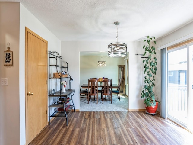 2917 SW Coves Dr, Ankeny, IA 50023 - dining area with a chandelier, a textured ceiling, baseboards, and wood finished floors