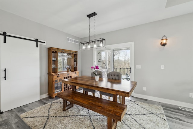 875 Roman Rd, Waukee, IA 50263 - dining room with a barn door, wood finished floors, and baseboards