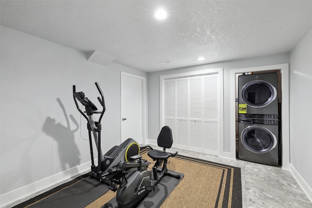 875 Roman Rd, Waukee, IA 50263 - exercise area with estacked washer and dryer, a textured ceiling, baseboards, and recessed lighting
