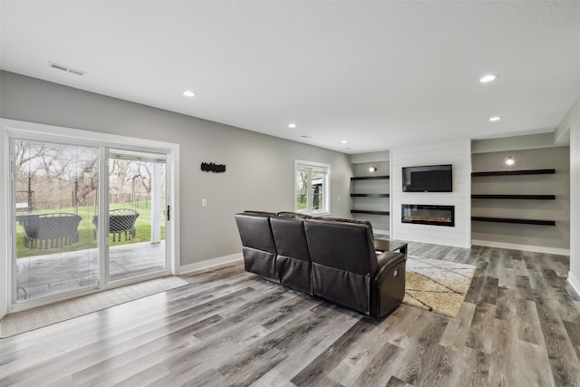 875 Roman Rd, Waukee, IA 50263 - living room featuring wood finished floors, baseboards, a fireplace, built in features, and recessed lighting