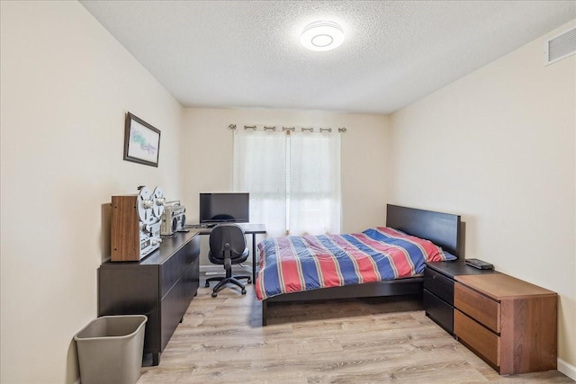 5417 NW 92nd St, Johnston, IA 50131 - bedroom with a textured ceiling, light wood finished floors, and a desk