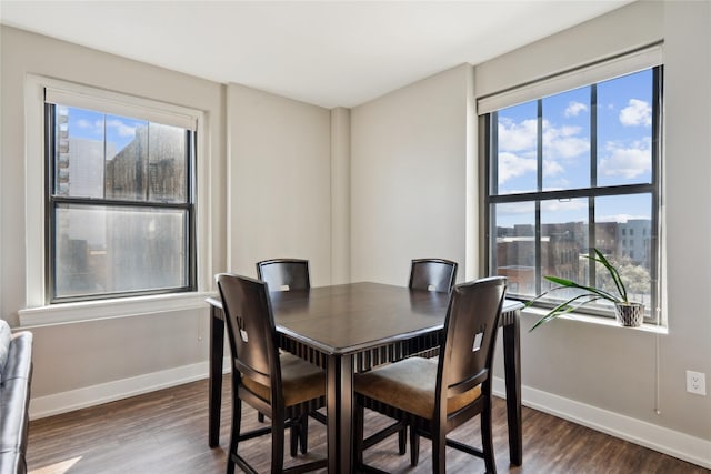 dining space with baseboards and wood finished floors