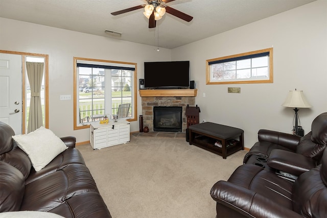 921 10th St SE, Altoona, IA 50009 - carpeted living area with a ceiling fan, a stone fireplace, and healthy amount of natural light