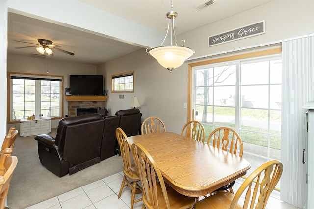 921 10th St SE, Altoona, IA 50009 - dining room with ceiling fan, light tile patterned floors, a fireplace, and light carpet