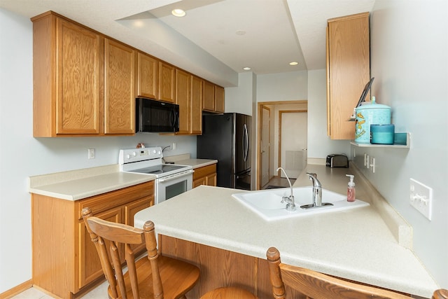 921 10th St SE, Altoona, IA 50009 - kitchen featuring black microwave, white electric stove, freestanding refrigerator, a breakfast bar area, and a peninsula