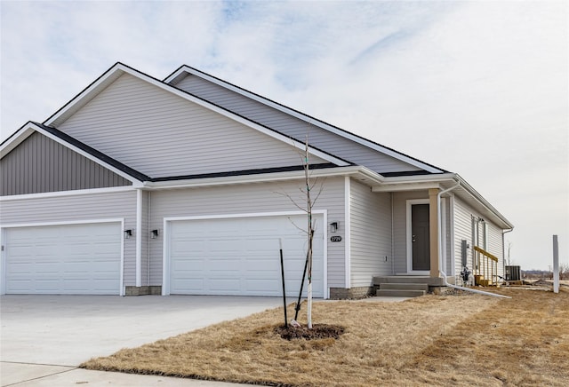 ranch-style home with entry steps, a garage, driveway, and central AC