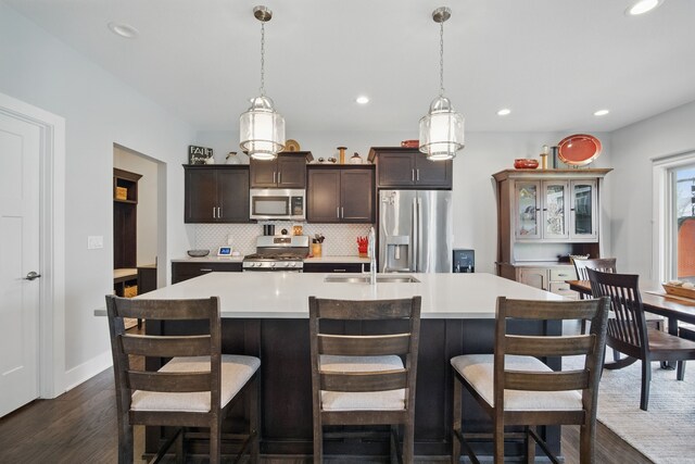 8704 Highland Oaks Dr, Johnston, IA 50131 - kitchen featuring appliances with stainless steel finishes, a sink, dark wood finished floors, light countertops, and recessed lighting