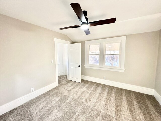 unfurnished bedroom featuring lofted ceiling, baseboards, a ceiling fan, and carpet floors