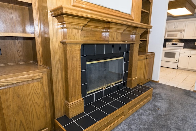 5925 Ep True Pkwy Unit 22, West Des Moines, IA 50266 - detailed view of white appliances, a tiled fireplace, backsplash, and carpet