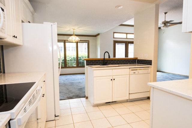 5925 Ep True Pkwy Unit 22, West Des Moines, IA 50266 - kitchen with white appliances, a sink, light carpet, a chandelier, and white cabinetry