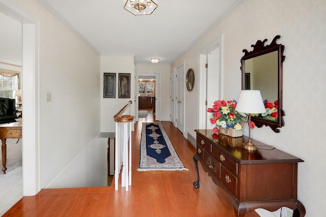 1113 Bruce Ln, Pella, IA 50219 - hall featuring an upstairs landing, ornamental molding, and wood finished floors
