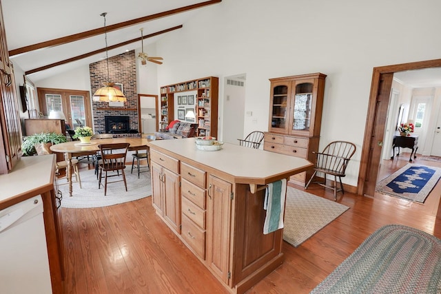 1113 Bruce Ln, Pella, IA 50219 - kitchen featuring light wood-type flooring, a ceiling fan, a brick fireplace, high vaulted ceiling, and white dishwasher