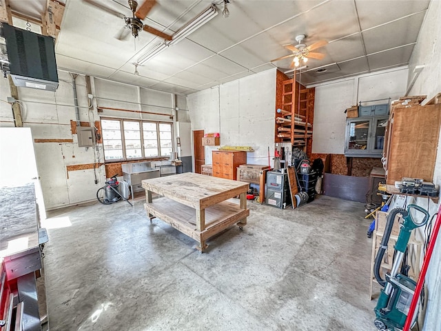 1009 198th Pl, Pella, IA 50219 - garage featuring a ceiling fan, a workshop area, electric panel, and a heating unit
