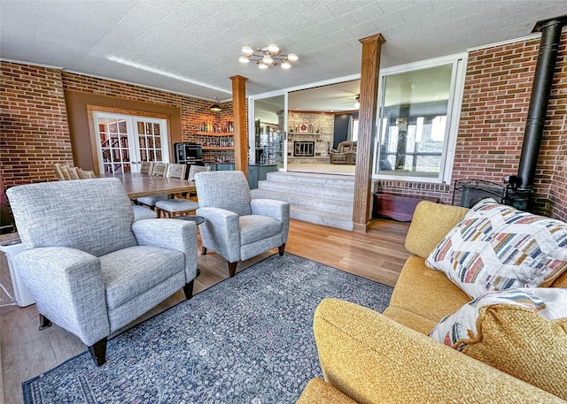 1009 198th Pl, Pella, IA 50219 - sunroom / solarium with french doors, a wood stove, and a chandelier