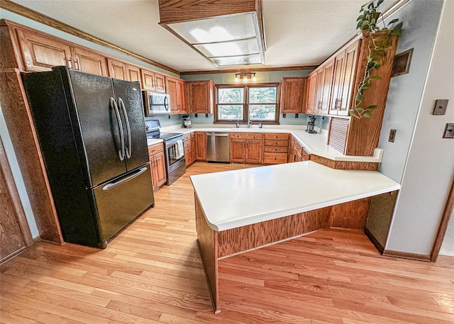 1009 198th Pl, Pella, IA 50219 - kitchen featuring appliances with stainless steel finishes, a peninsula, light wood-style floors, and crown molding