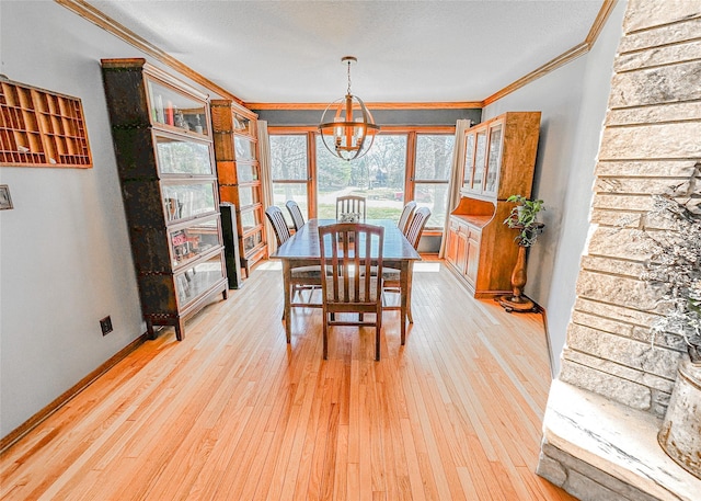 1009 198th Pl, Pella, IA 50219 - dining space with a chandelier, ornamental molding, light wood-style flooring, and baseboards