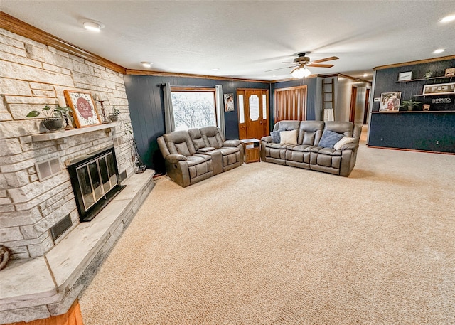 1009 198th Pl, Pella, IA 50219 - living area featuring ornamental molding, a stone fireplace, carpet floors, a ceiling fan, and a textured ceiling