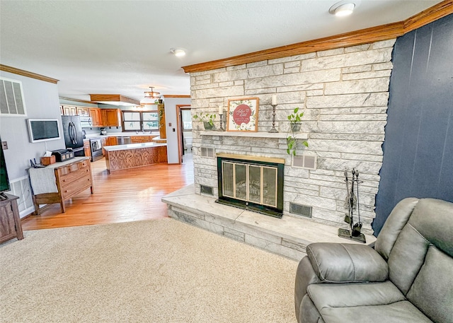 1009 198th Pl, Pella, IA 50219 - living room with light wood-style floors, ornamental molding, and a fireplace