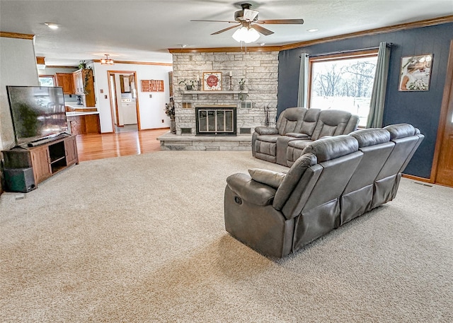 1009 198th Pl, Pella, IA 50219 - carpeted living area featuring crown molding, a ceiling fan, a fireplace, and baseboards