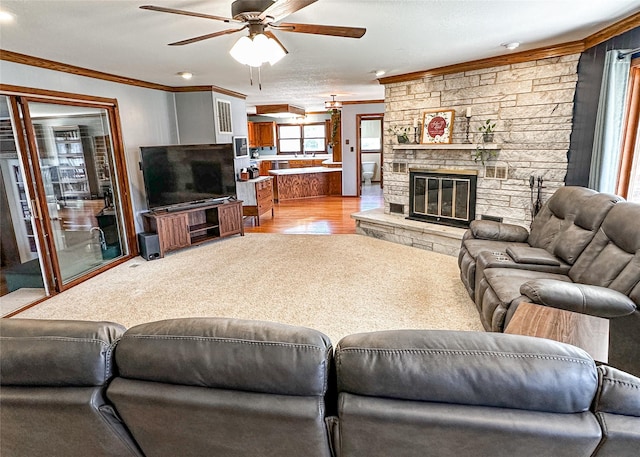 1009 198th Pl, Pella, IA 50219 - living area with ornamental molding, ceiling fan, a fireplace, and light wood-type flooring