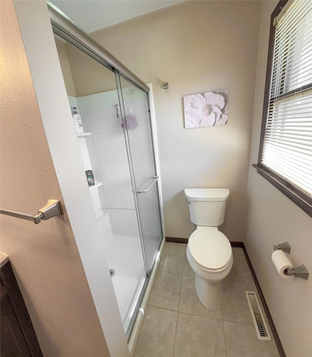 1009 198th Pl, Pella, IA 50219 - full bathroom featuring a stall shower, toilet, tile patterned floors, and baseboards