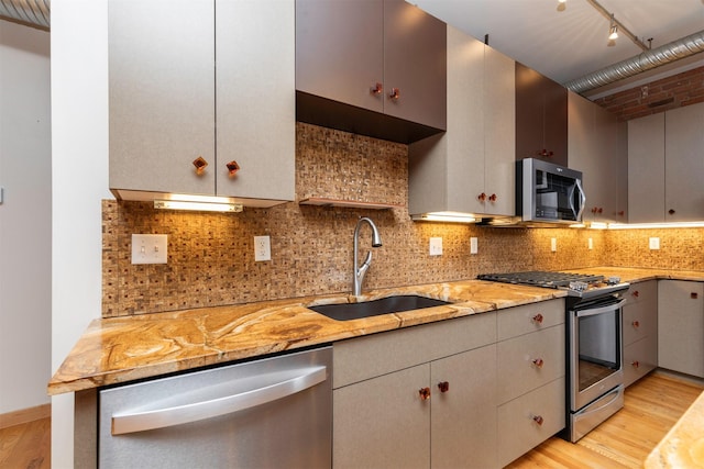 301 E Court Ave Unit 203, Des Moines, IA 50309 - kitchen with stainless steel appliances, light wood finished floors, light stone counters, and tasteful backsplash