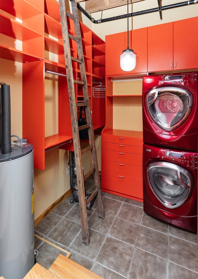 301 E Court Ave Unit 203, Des Moines, IA 50309 - washroom with stacked washer and clothes dryer, water heater, and dark tile patterned floors