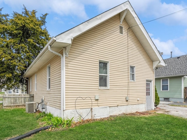 view of property exterior featuring fence, cooling unit, and a lawn