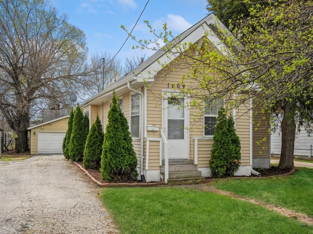 view of front of home featuring an outbuilding, a front yard, entry steps, and a garage