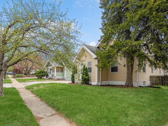 view of front of home featuring fence and a front lawn