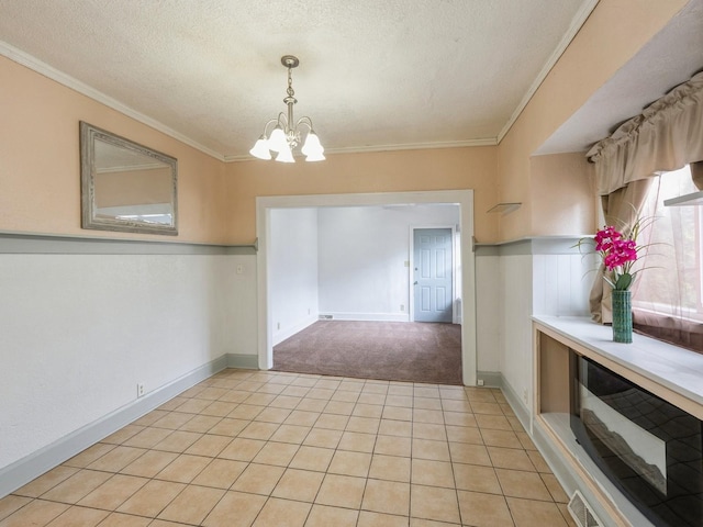 unfurnished dining area with a textured ceiling, an inviting chandelier, and crown molding