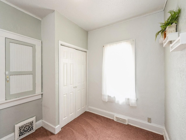 unfurnished bedroom featuring a closet, carpet flooring, baseboards, and visible vents