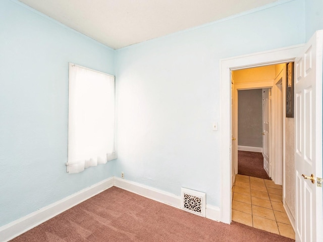 empty room featuring visible vents, baseboards, and carpet