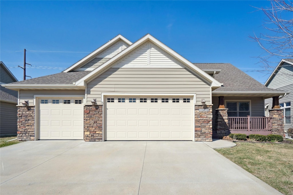 craftsman house featuring roof with shingles, a garage, and concrete driveway