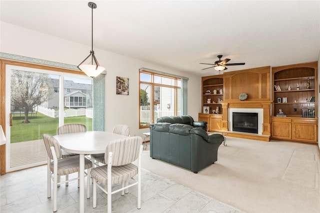 9040 Telford Cir, Johnston, IA 50131 - dining area with a ceiling fan and a glass covered fireplace