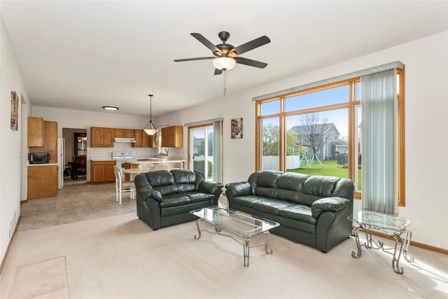 9040 Telford Cir, Johnston, IA 50131 - living area featuring light carpet, ceiling fan, and baseboards