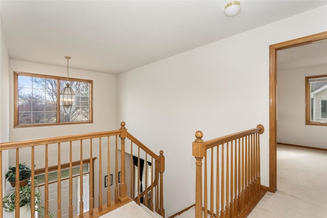 9040 Telford Cir, Johnston, IA 50131 - staircase featuring carpet floors, baseboards, and a chandelier