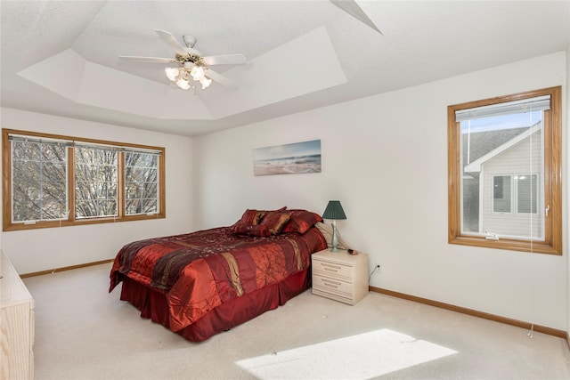 9040 Telford Cir, Johnston, IA 50131 - carpeted bedroom featuring baseboards, a raised ceiling, and a ceiling fan